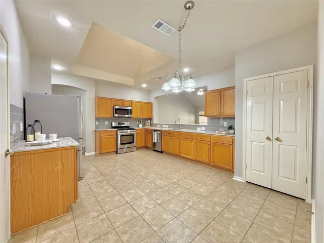 a large kitchen with kitchen island a sink stainless steel appliances and cabinets
