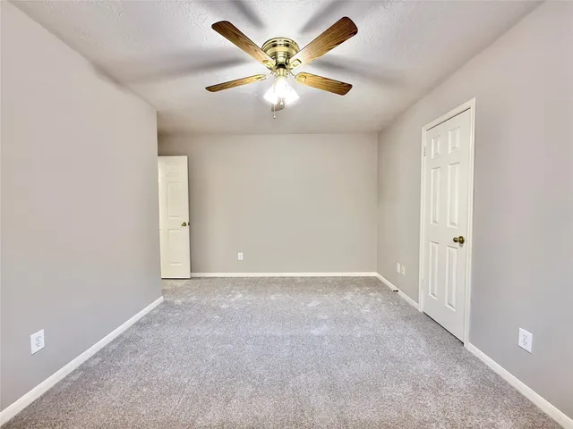 an empty room with closet and a chandelier fan
