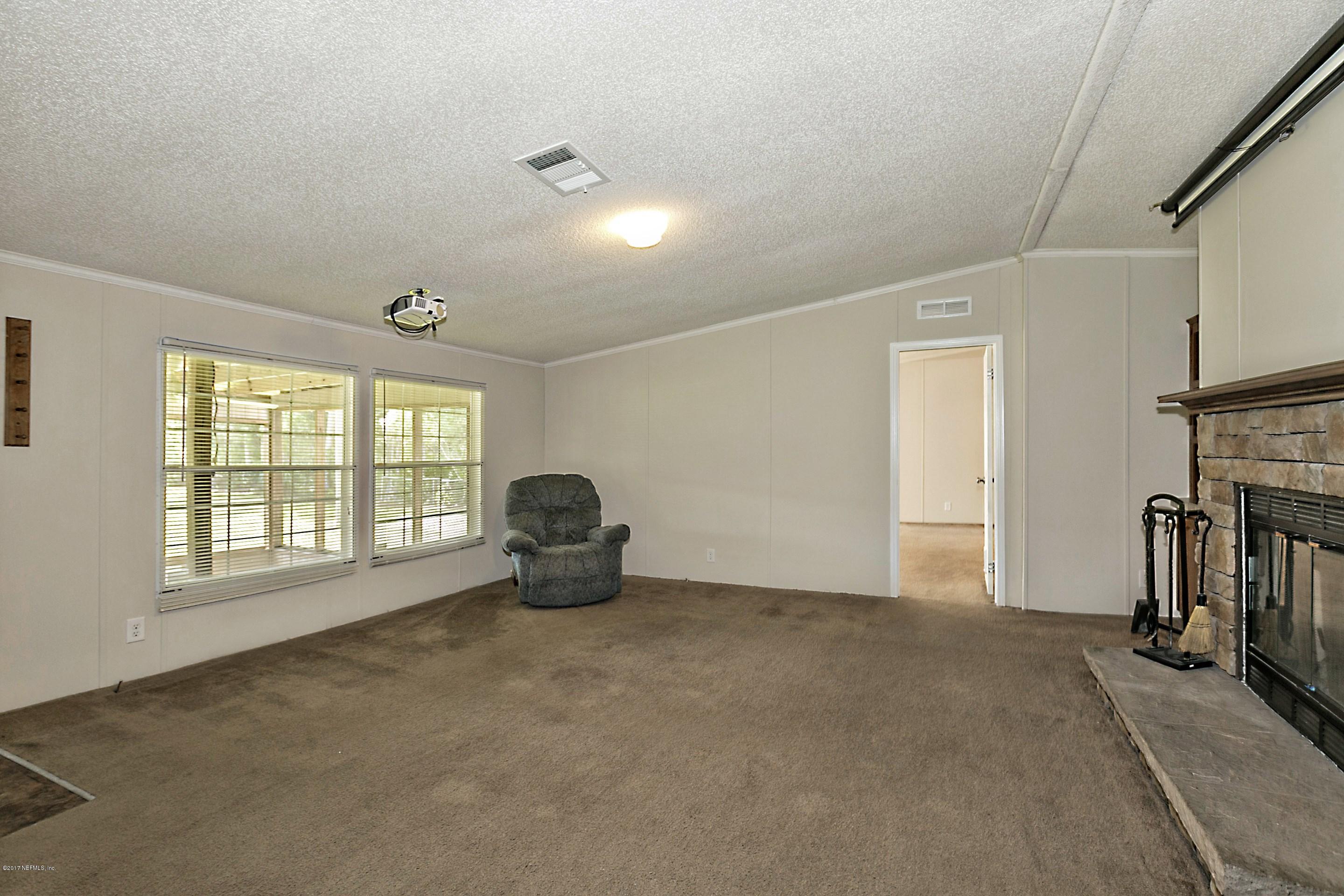 324 Dusty Road St. Augustine, FL 32095 - Photo 8 of 26 a view of an empty room with a fireplace and a window