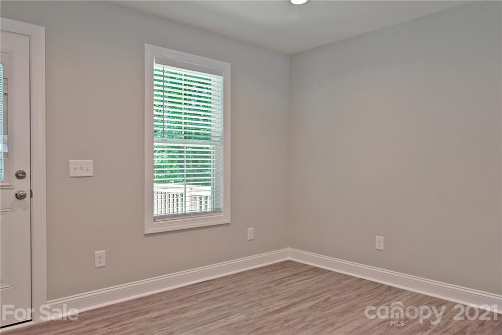 131 Powder Street Southwest Concord, NC 28025 - Photo 12 of 29 a view of an empty room with wooden floor and a window