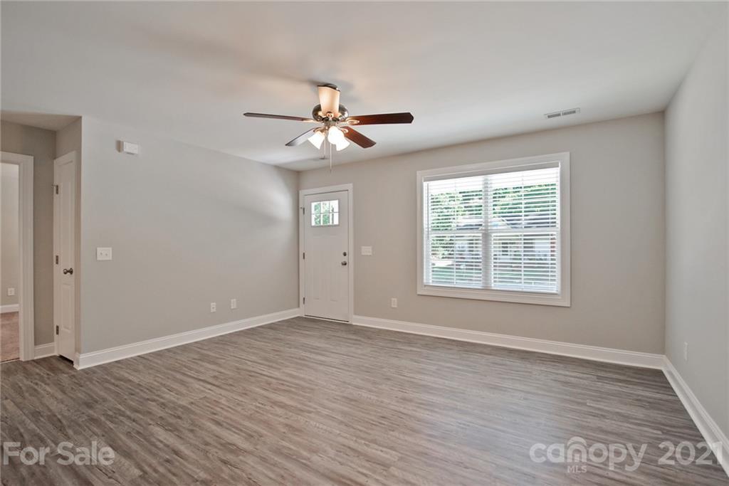 131 Powder Street Southwest Concord, NC 28025 - Photo 25 of 29 a view of an empty room with a window and wooden floor