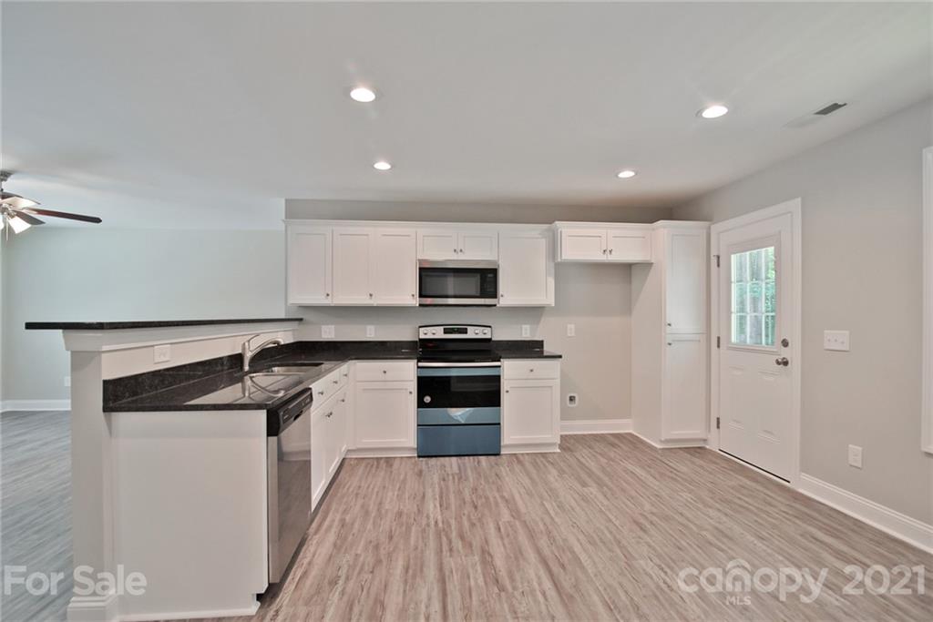 131 Powder Street Southwest Concord, NC 28025 - Photo 26 of 29 a kitchen with a sink stove and refrigerator