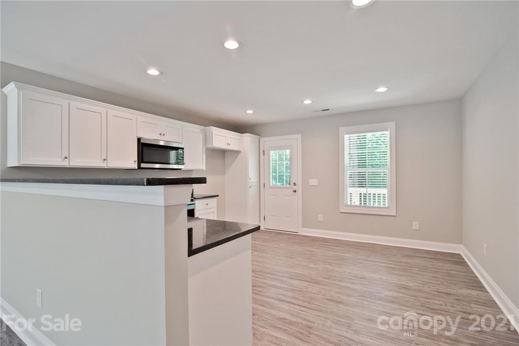131 Powder Street Southwest Concord, NC 28025 - Photo 9 of 29 a kitchen with stainless steel appliances granite countertop a refrigerator a sink a stove a microwave and cabinets
