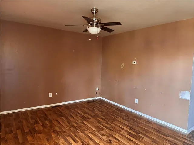 a view of an empty room with a ceiling fan and window