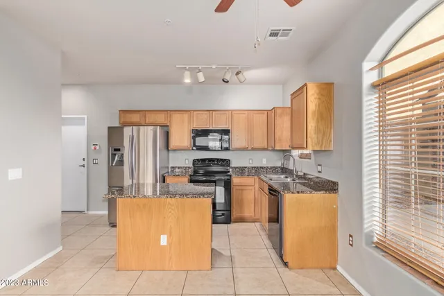 a kitchen with stainless steel appliances granite countertop a stove a sink and a refrigerator