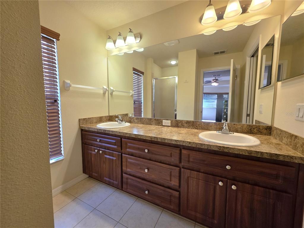 4284 High Ridge Avenue Spring Hill, FL 34609 - Photo 26 of 40 a bathroom with a granite countertop sink a large mirror and a vanity