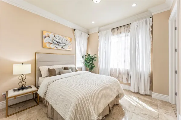 a bedroom with a large bed and wooden floor