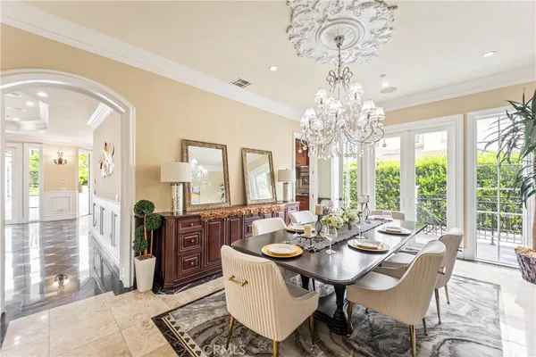 a view of a dining room with furniture a chandelier and wooden floor