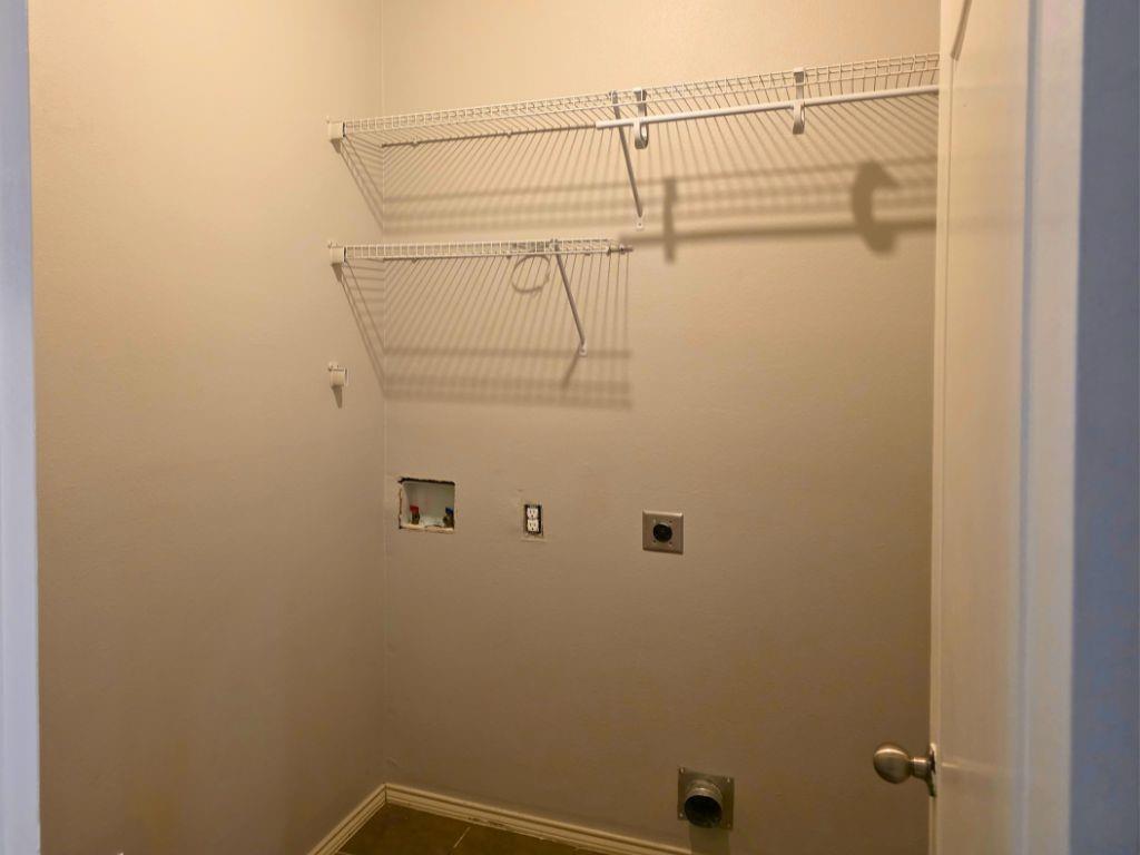 6320 Spring Ranch Drive Fort Worth, TX 76179 - Photo 6 of 24 Utility room with two levels of wire shelving, a dryer vent hookup, and a washer hookup