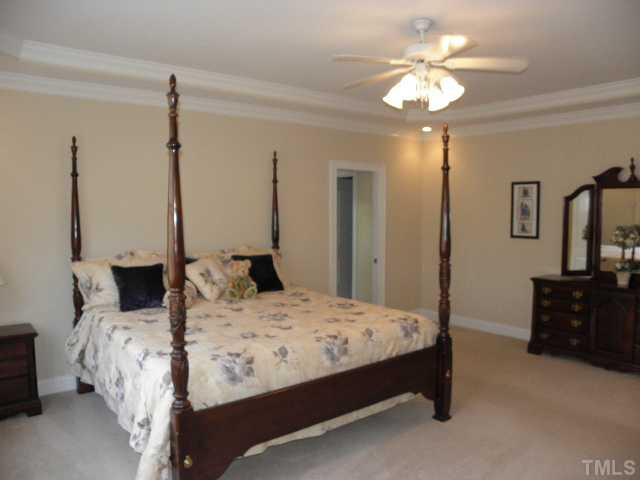 7009 Millstone Ridge Court Raleigh, NC 27614 - Photo 15 of 25 a bedroom with a bed a chandelier and a dresser