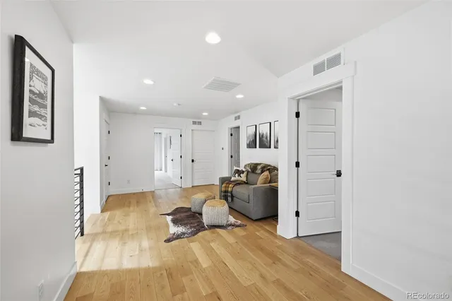 a living room with furniture a refrigerator and a table