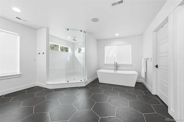 a large white kitchen with a large window vanity and stainless steel appliances