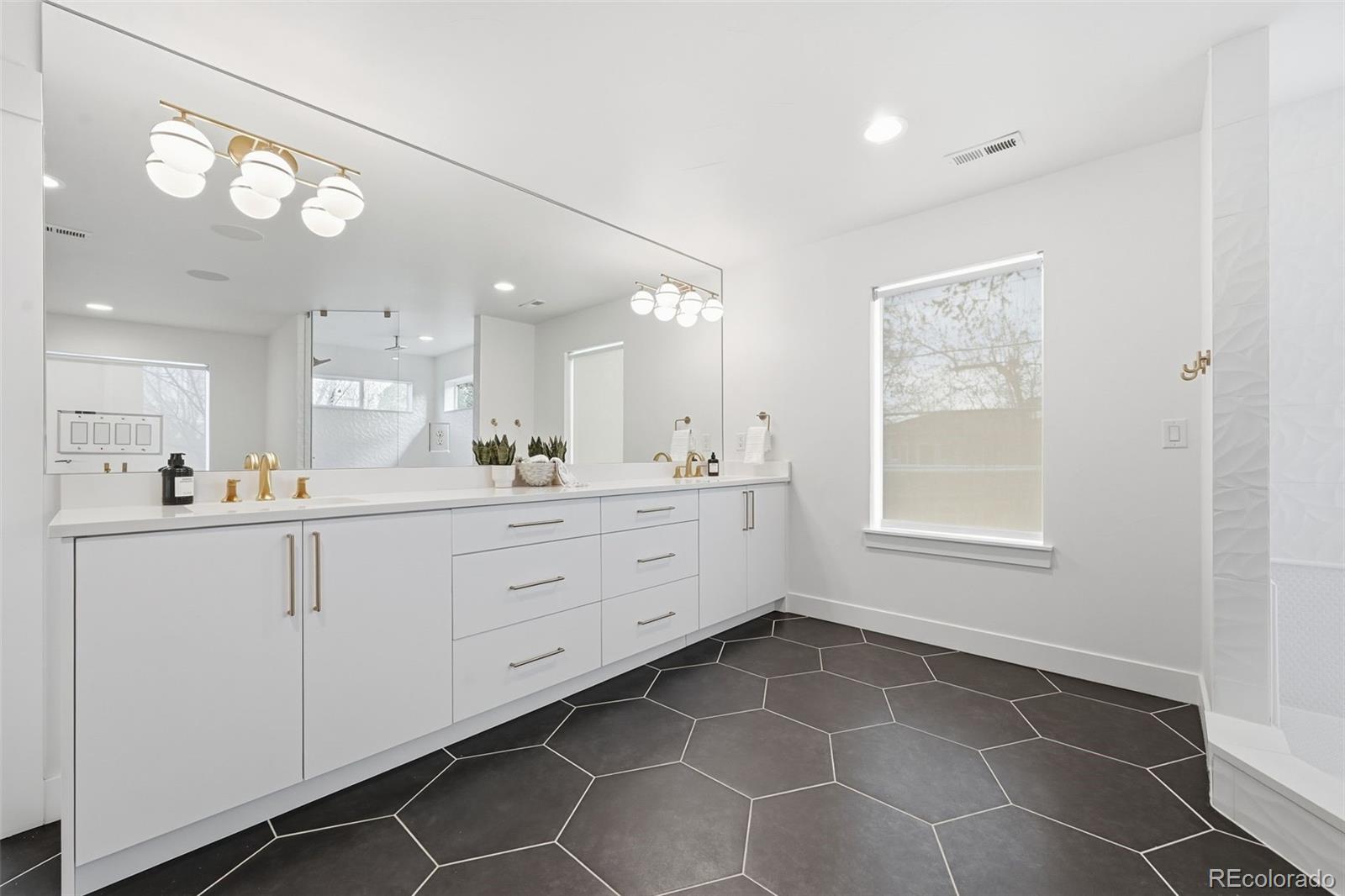 2757 South Steele Street Denver, CO 80210 - Photo 36 of 50 a large white kitchen with a large window vanity and stainless steel appliances