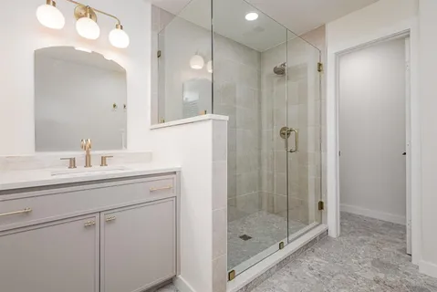 a bathroom with a shower sink and mirror