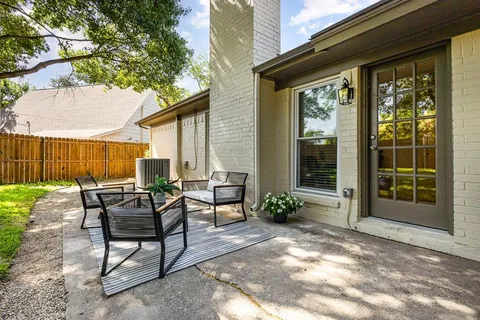 a view of a house with backyard and sitting area