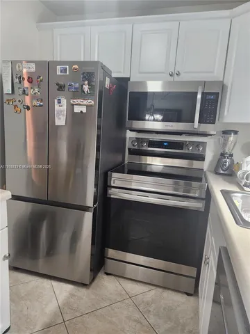 a metallic refrigerator freezer sitting in a kitchen