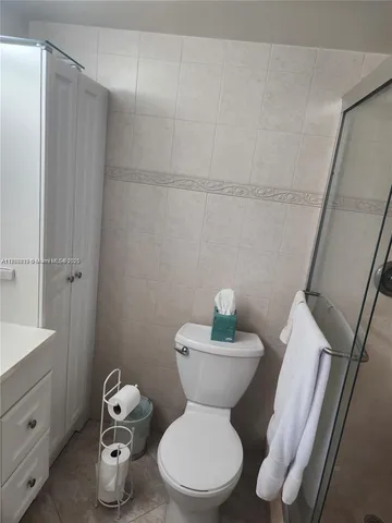 a white toilet sitting next to a bathroom sink and vanity