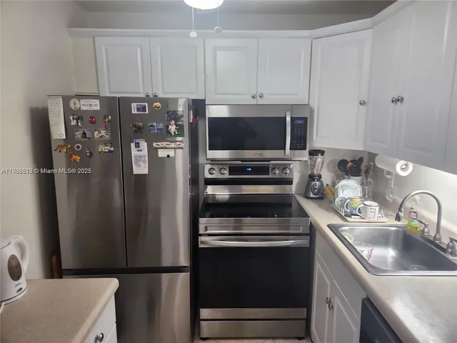 a kitchen with stainless steel appliances a refrigerator sink and microwave