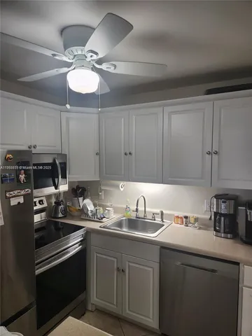 a kitchen with a sink cabinets and stainless steel appliances