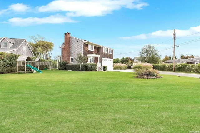 a backyard of a house with table and chairs