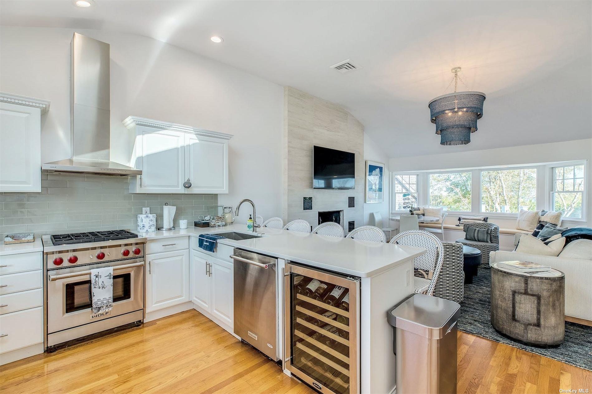 25 Exchange Westhampton Beach, NY 11978 - Photo 16 of 31 a open kitchen with stainless steel appliances granite countertop a stove top oven a sink dishwasher and white cabinets with wooden floor