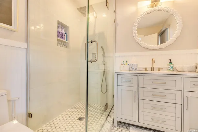 a bathroom with a shower a sink and a mirror