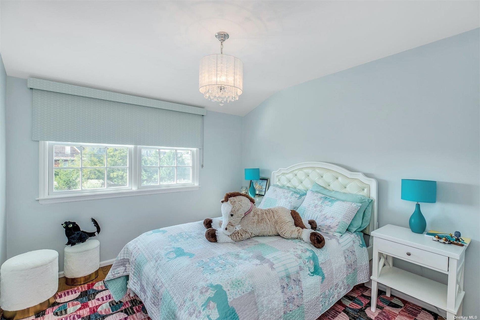 25 Exchange Westhampton Beach, NY 11978 - Photo 24 of 31 a bedroom with a bed and a chandelier