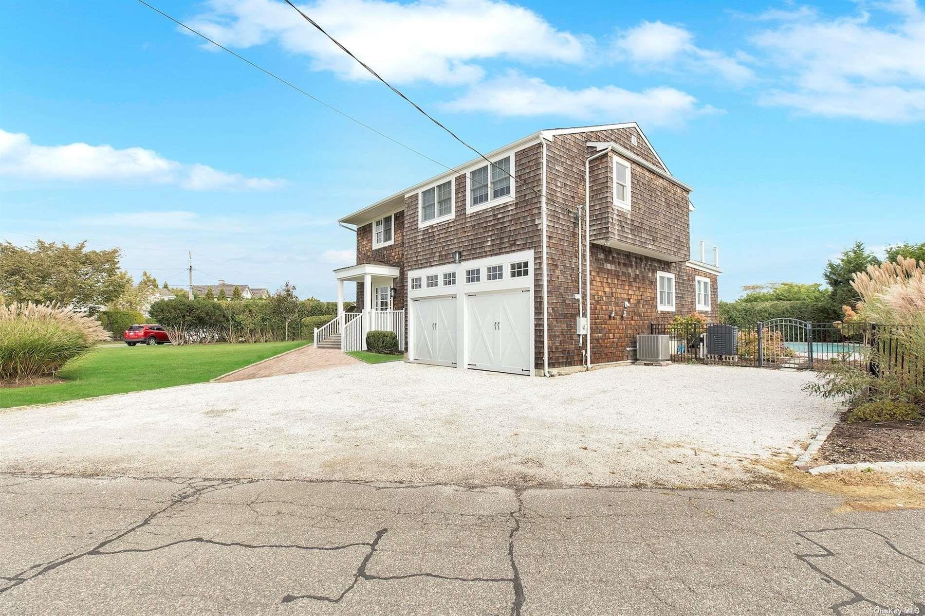25 Exchange Westhampton Beach, NY 11978 - Photo 5 of 31 a front view of a house with a yard and garage