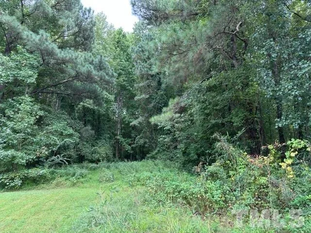 an aerial view of residential house with outdoor space and trees all around