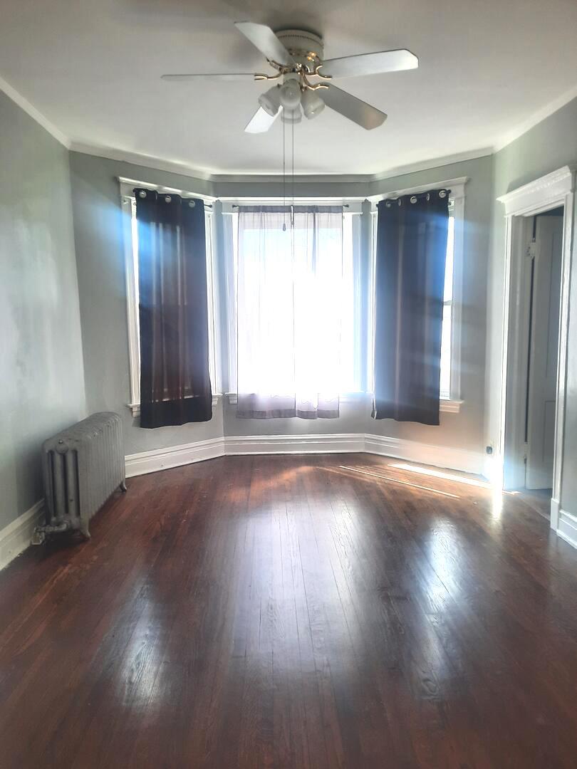 6221 South Laflin Street, Unit 2 Chicago, IL 60636 - Photo 4 of 20 an empty room with wooden floor and windows