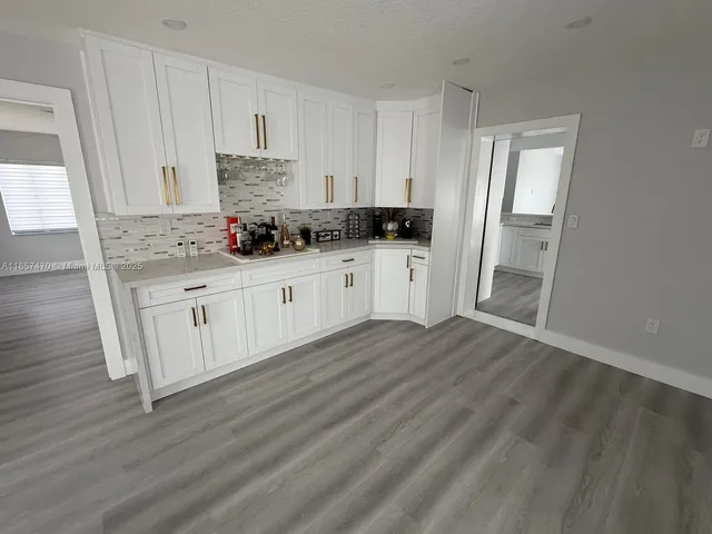 a kitchen with granite countertop a sink and cabinets