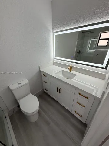 a bathroom with a toilet sink and mirror