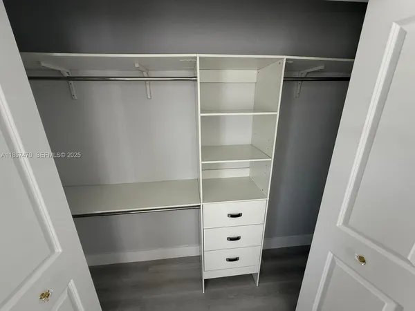 a view of walk in closet with empty racks