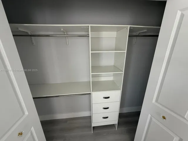 a view of walk in closet with empty racks