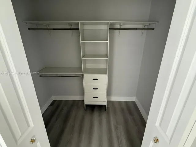 a view of walk in closet with empty racks