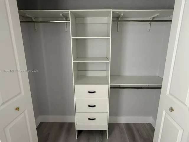 a view of walk in closet with empty racks