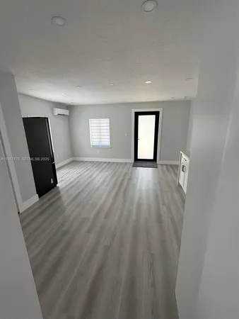 a view of a room with wooden floor and window