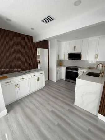 a kitchen with white cabinets and black appliances