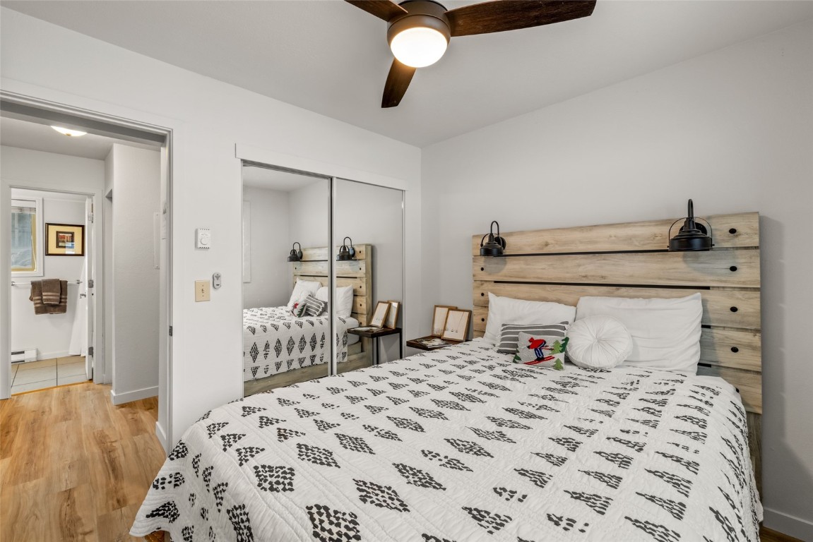 1565 Shadow Run Frontage, Unit B103 Steamboat Springs, CO 80487 - Photo 14 of 28 a bedroom with a bed and wooden floor