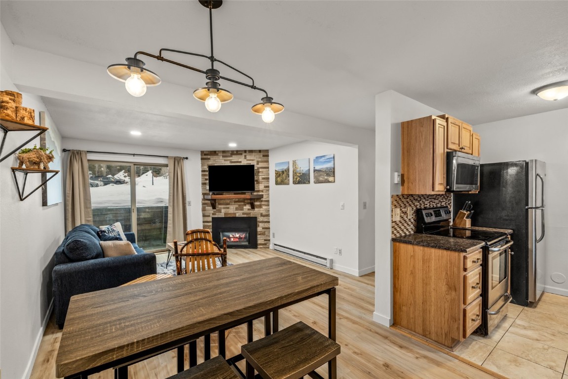 1565 Shadow Run Frontage, Unit B103 Steamboat Springs, CO 80487 - Photo 5 of 28 a view of a dining room with furniture a kitchen and chandelier