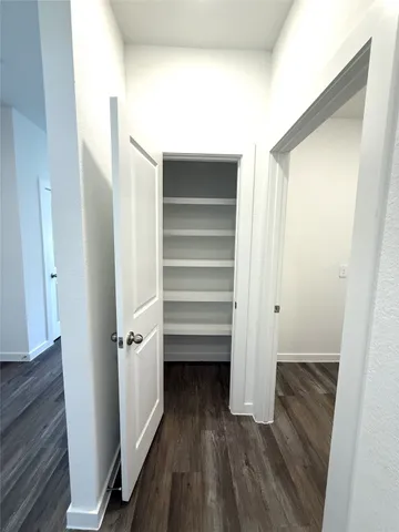 a view of walk in closet with wooden floor