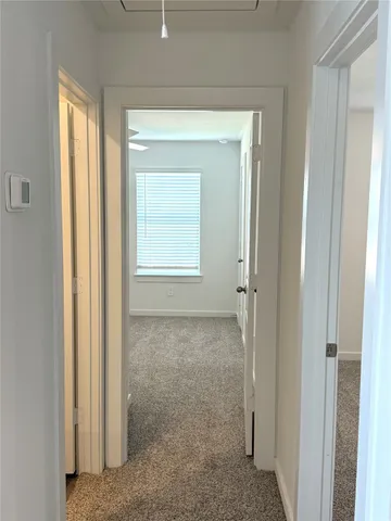 a view of an empty room with closet and a window