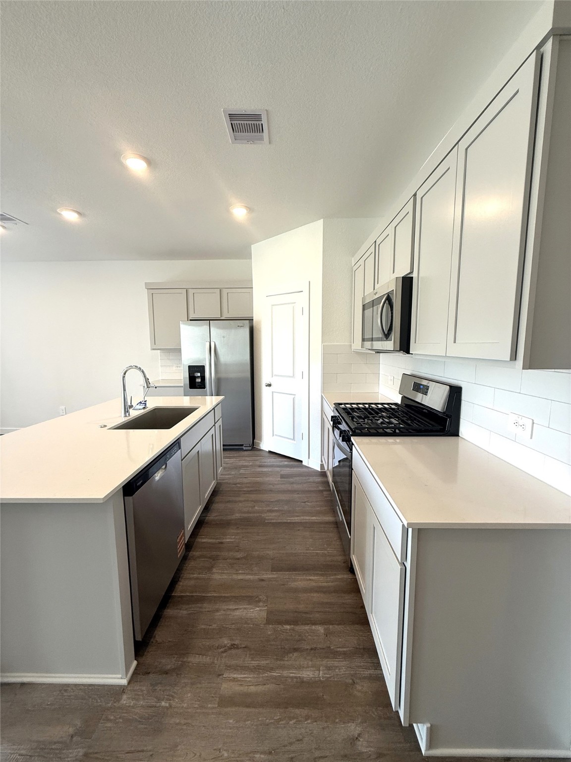4308 Wallace Falls Lane Conroe, TX 77303 - Photo 3 of 27 a large kitchen with stainless steel appliances kitchen island granite countertop a sink and dishwasher a stove with wooden floor
