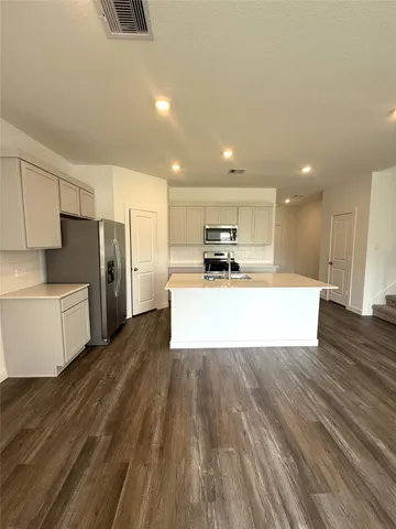 a large kitchen with a center island stainless steel appliances and cabinets