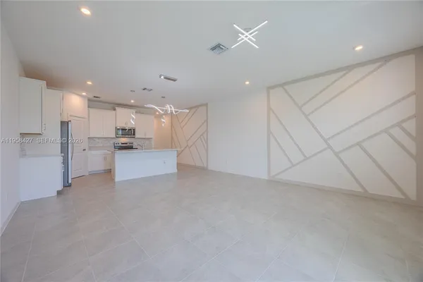 a view of a kitchen with refrigerator and a sink