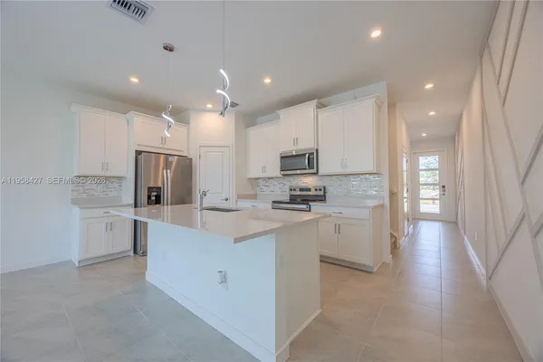 a kitchen with white cabinets and stainless steel appliances