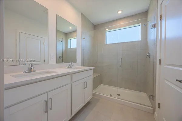 a bathroom with a shower sink vanity and mirror