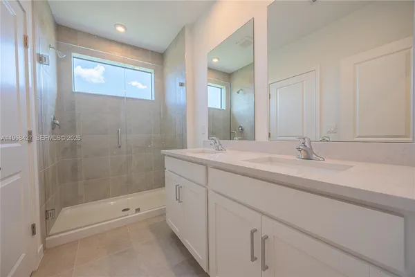 a bathroom with double sink and a mirror