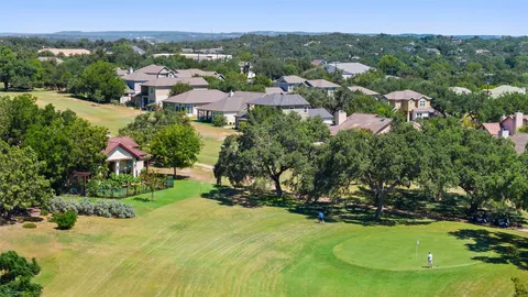 an aerial view of residential house with outdoor space and trees all around