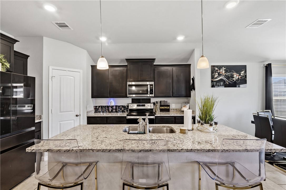 2009 Chief Street Bryan, TX 77807 - Photo 9 of 27 a kitchen with kitchen island granite countertop a counter space cabinets and stainless steel appliances